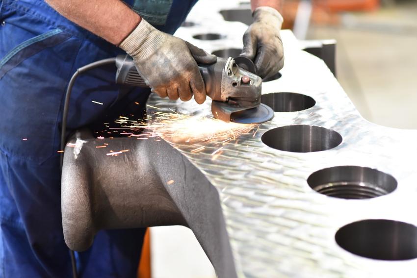 Bearbeitung eines metallischen Werkstueckes mit einer Schleifmaschine Flex im Maschinenbau