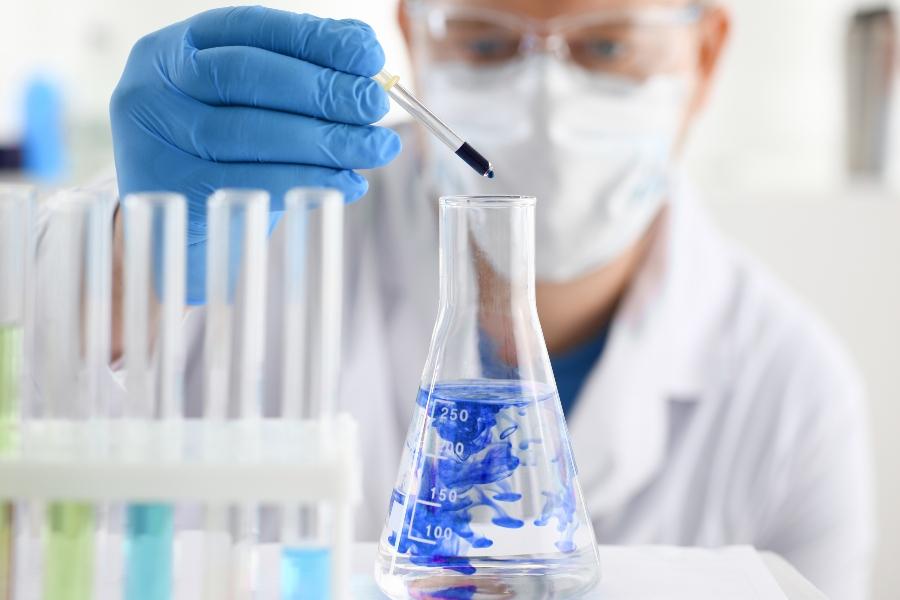 Chemiker mit Reagenzglas mitarbeiterschutz-bei-chemischen-prozessen