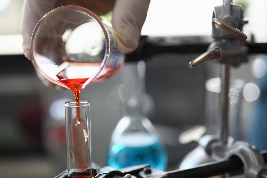 Rote Flüssigkeit wird in ein Ragenzglas gefüllt - Lösungsmittel in der chemischen Industrie